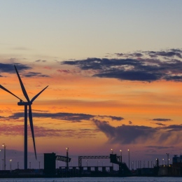 Windmills by city in sunset